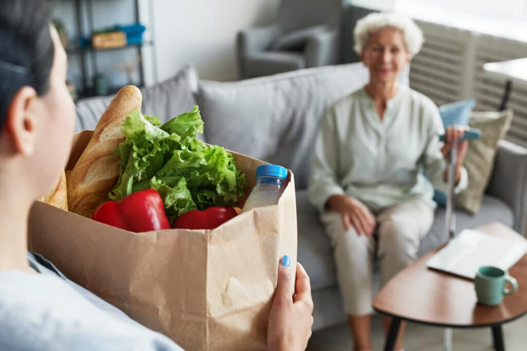 Senior receiving nutritious meal support from a home health aide in San Diego.