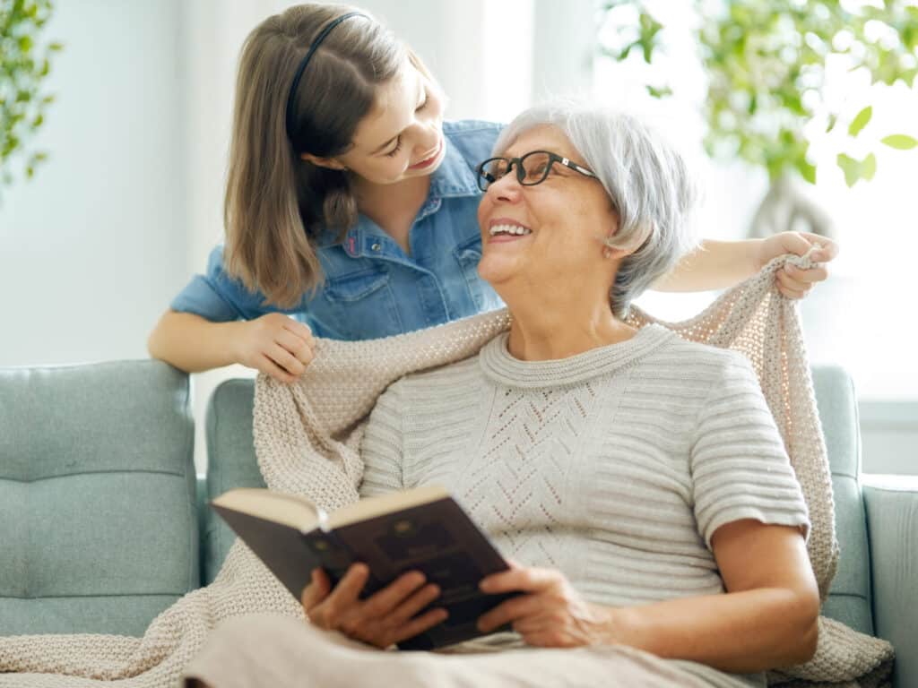 Caregiver assisting an elderly woman with La Mesa senior home care, offering companionship and support in a cozy, home setting.